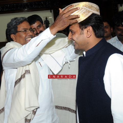 Karnataka CM Siddaramaiah placing 'Mysore Peta'  on UP CM Akhilesh Yadav.