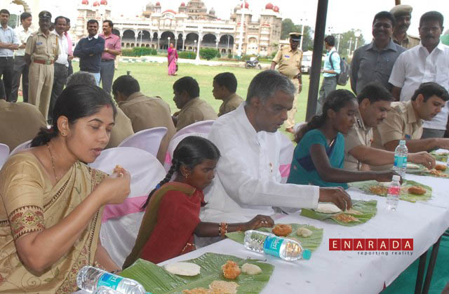 The district in-charge minister V Srinivasa Prasad and senior Government officials having breakfast with the mahouts, kavaids and their family members